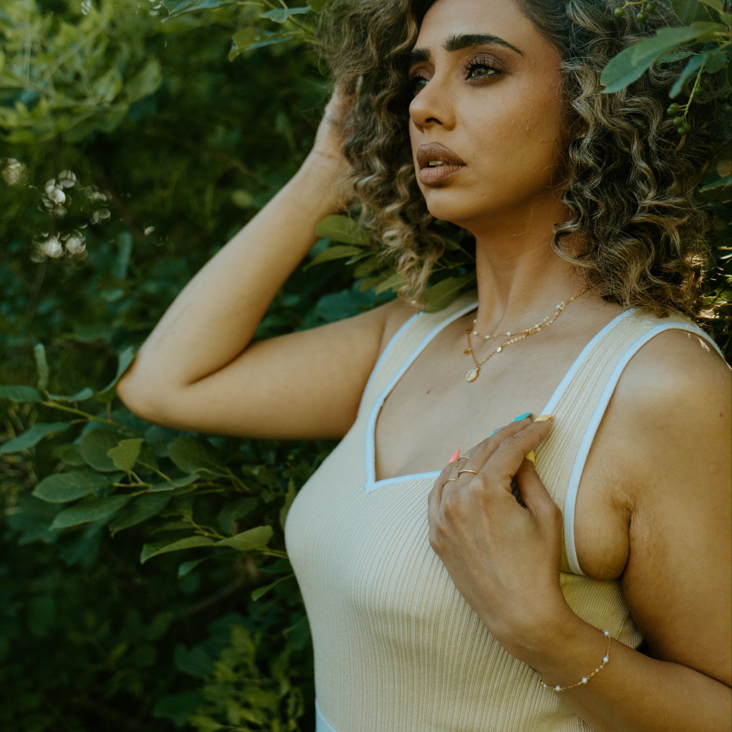 woman wearing pearl necklace and coin necklace