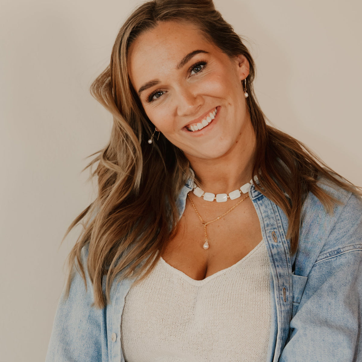 shell necklace, layered with pearl lariat necklace and pearl ear thread earring