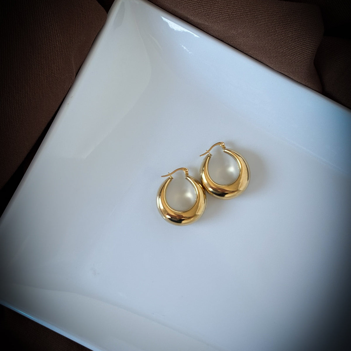 lose-up of Maggie Hoops with a smooth chunky gold crescent shape
