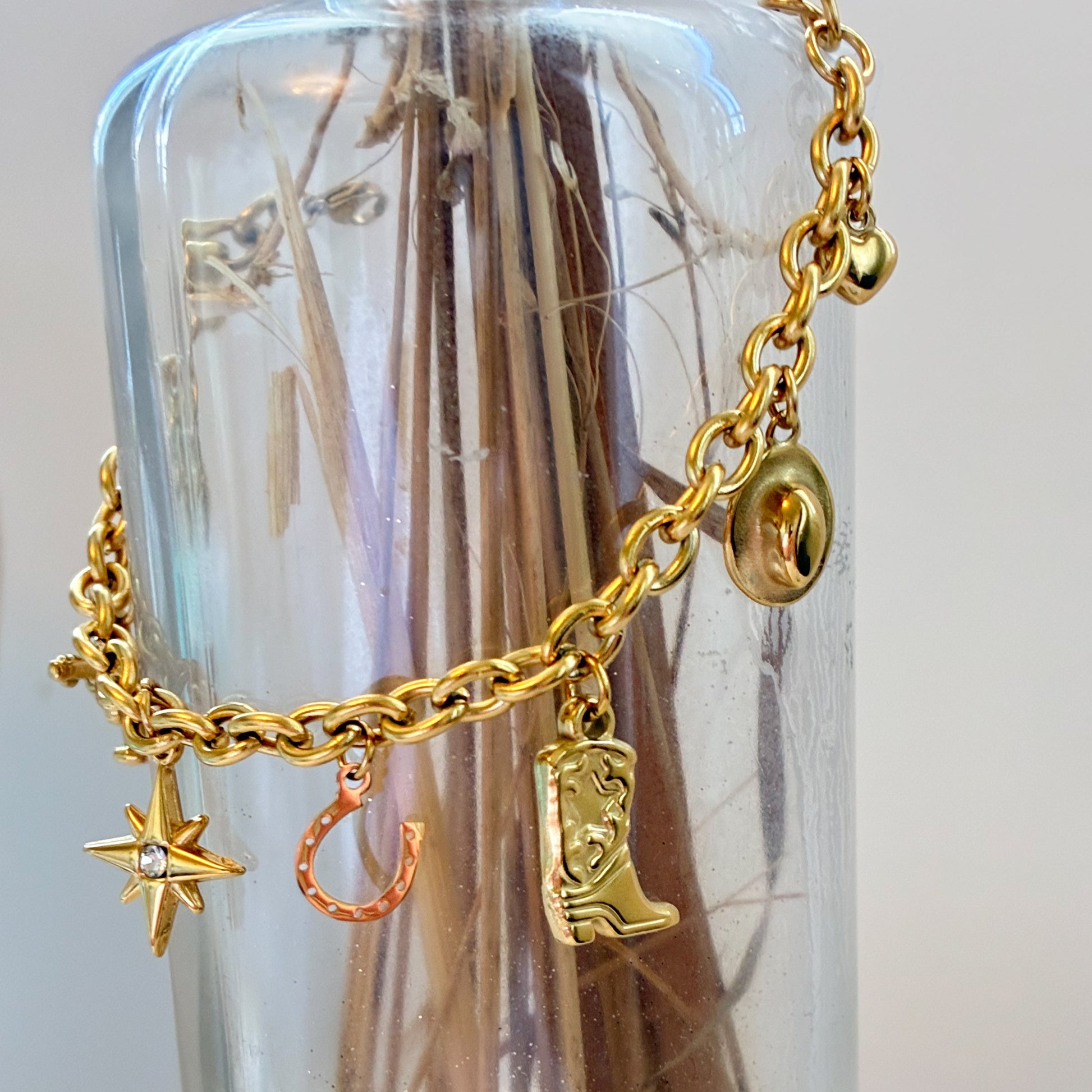 Gold charm bracelet with star, cowboy hat, horseshoe, gun, heart, and boot charms non tarnishing golden bracelet with meaning 