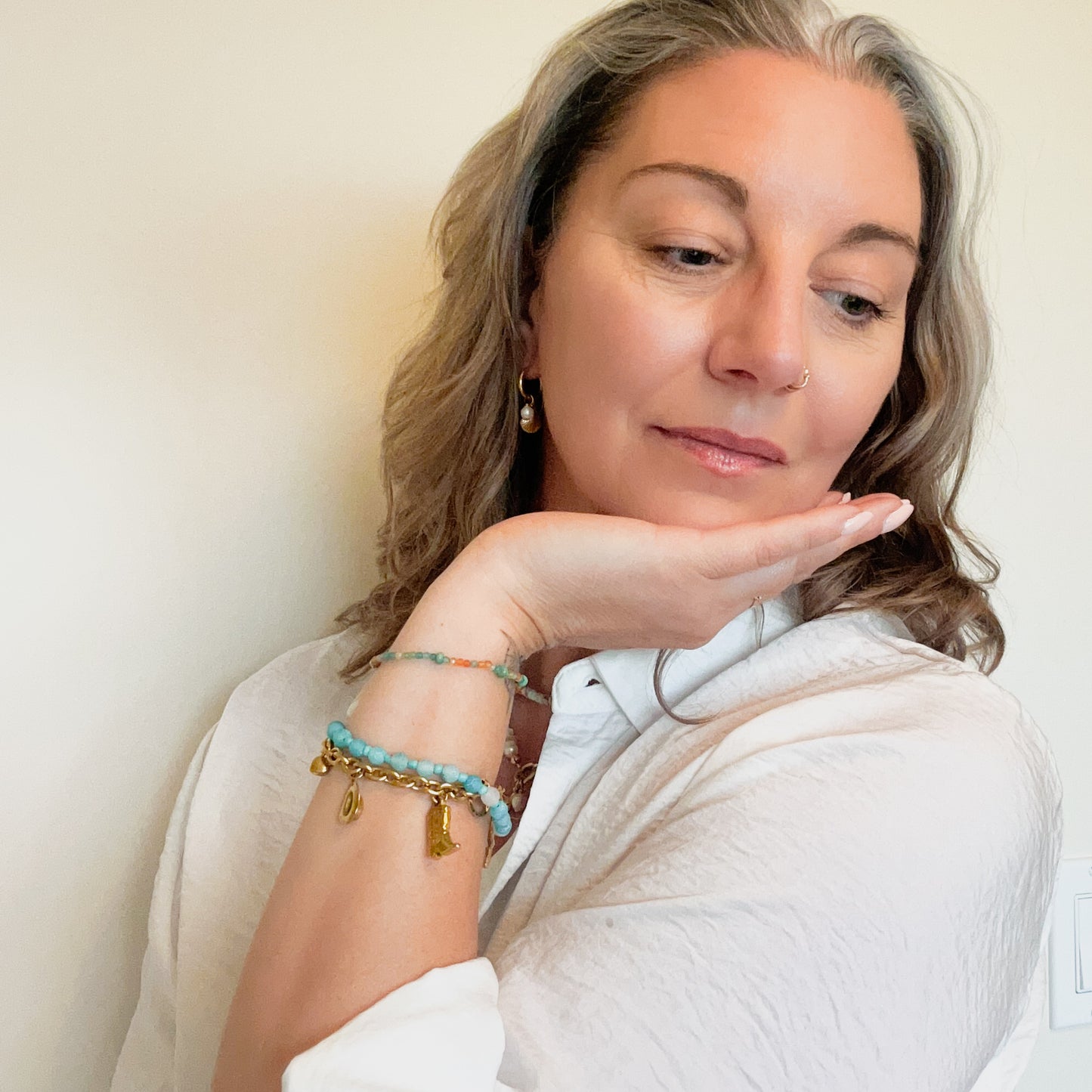 woman wearing country charm bracelet with beaded beach jewelry, meaningful jewelry that gives back to mental health awareness