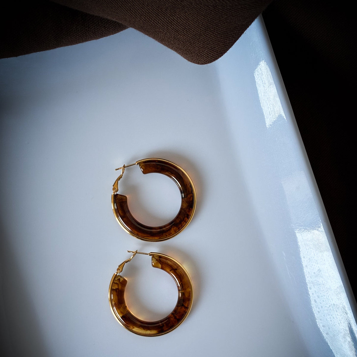 Close-up of After Hours Hoops with chocolate brown resin and gold detailing