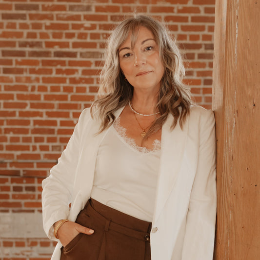 Woman wearing A Little Bit of Brave gold compass rose necklace by Isla Rae Jewelry, layered as meaningful everyday jewelry.