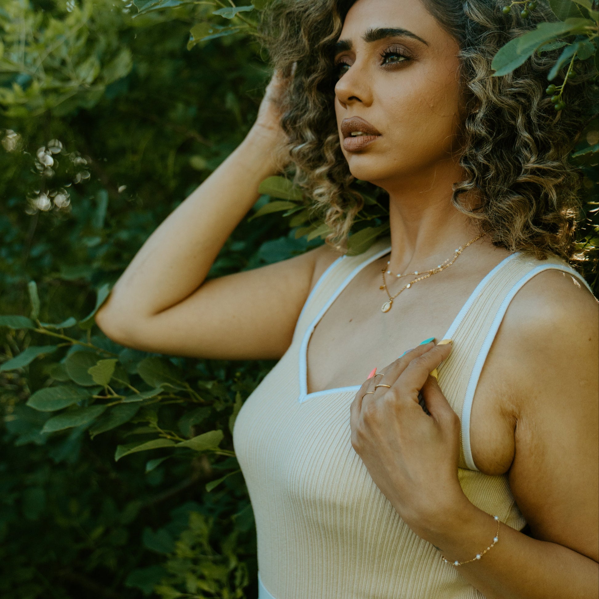 woman wearing pearl necklace and coin necklace